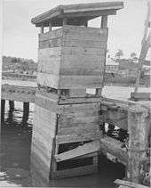 Latrines provisoires (aux Pilippines), au-dessus de l'eau, en bordure de ponton, avec incinération de déchets