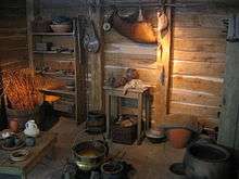 Reconstitution hypothétique d'un habitat gaulois : mobilier limité aux banquettes de couchage, aux objets de la vie quotidienne et aux éléments de stockage.