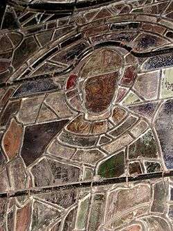 Détail d'un panneau du vitrail de Saint Thomas, cathédrale de Canterbury.
La surface peinte des verres est apparente. Les plombs en H sont visibles avec leurs jonctions soudées, de même que les fers raidisseurs et les fils de cuivre qui les lient au vitrail.