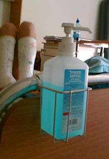 Flacon de désinfectant liquide, accroché en bout de lit dans un hôpital.