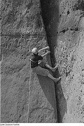 Un grimpeur allemand gravissant une fissure avec une simple corde autour du torse dans les années 1960.