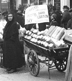 Marchande de paquets de confettis de 1 kilo dans une charrette de quatre saisons à Paris le Mardi Gras 24 février 1914. On remarquera les précisions : les confettis sont « unicolores[56] » et « garantis sans carton[57] ».