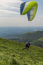 Parapentiste en phase de décollage dans une pente depuis le puy de Dôme en Auvergne, France.