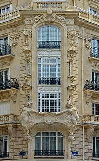 Un ensemble de fenêtres parisiennes sur un immeuble haussmannien.