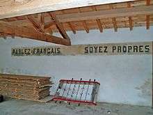  « Parlez français, soyez propres » panneau sur le mur d'une école du Sud de la France.