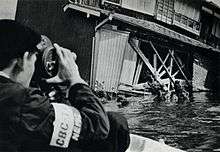 Photographe japonais filmant les dégâts laissés par le typhon Vera en banlieue de Nagoya, Japon, en septembre 1959. Le bilan humain s'éleva à 5 098 morts.