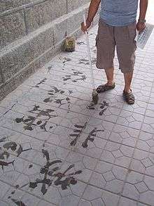 Chinois calligraphiant les classiques avec de l'eau